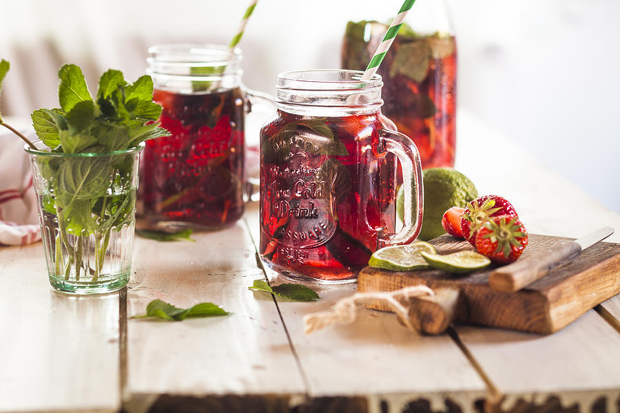Iced tea with fruits, hibiscus, strawberries, mint, limes Photograph by Westend61
