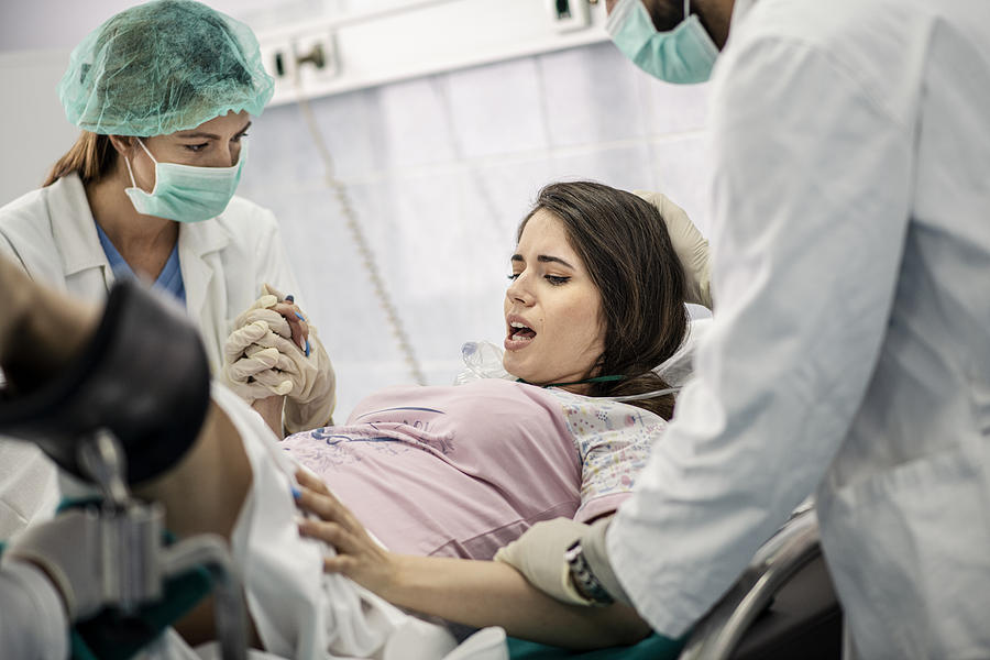 In the Hospital Woman Giving Birth Support, Obstetricians Assisting. Modern Delivery Ward with Professional Midwives #1 Photograph by Martinns