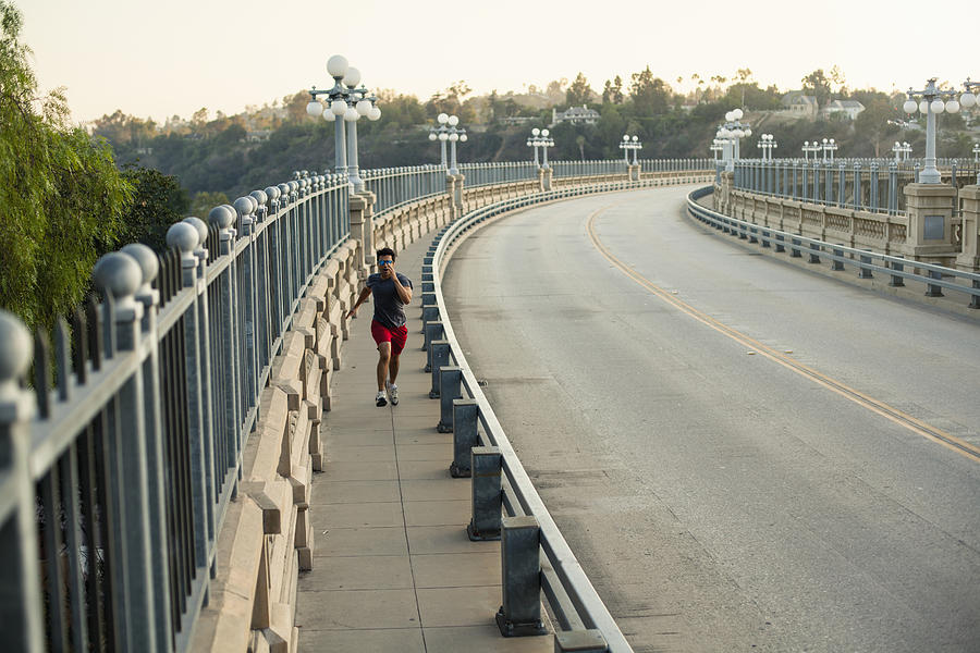 Jogger running on bridge, Arroyo Seco Park, Pasadena, California, USA #1 Photograph by Kevin Kozicki