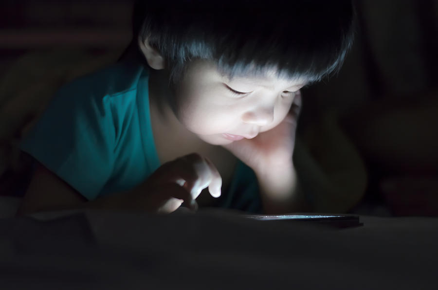 kid with tablet in the dark on bed and reading at Night . #1 Photograph by Anucha Sirivisansuwan