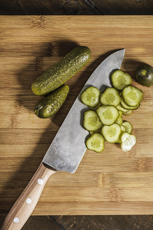Knife with chopped pickles on table #1 Photograph by Manuel Sulzer