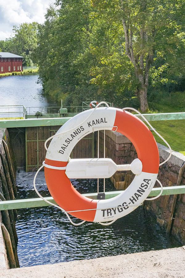 Lifebuoy at the Dalsland Canal locks at Dals Langed in Sweden on a summer day. #1 Photograph by Sjo