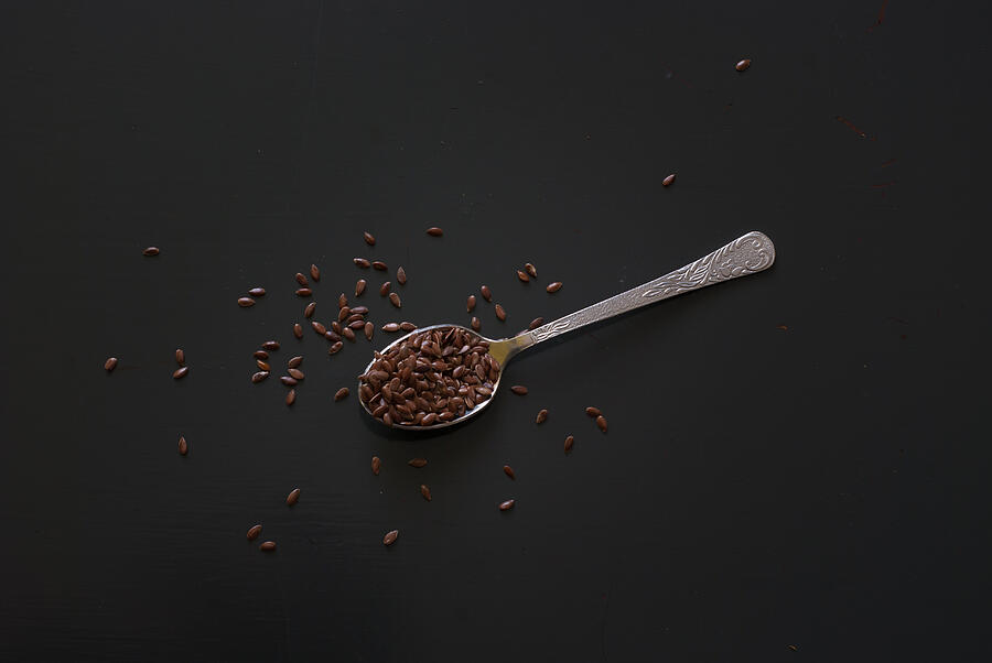 Linseed On Metal Spoon On Dark Wooden Table #1 Photograph by MichalDziedziak
