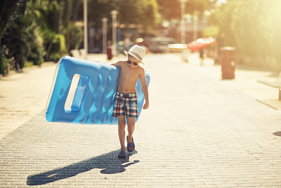 Little boy walking to the beach with an air bed #1 Photograph by Imgorthand