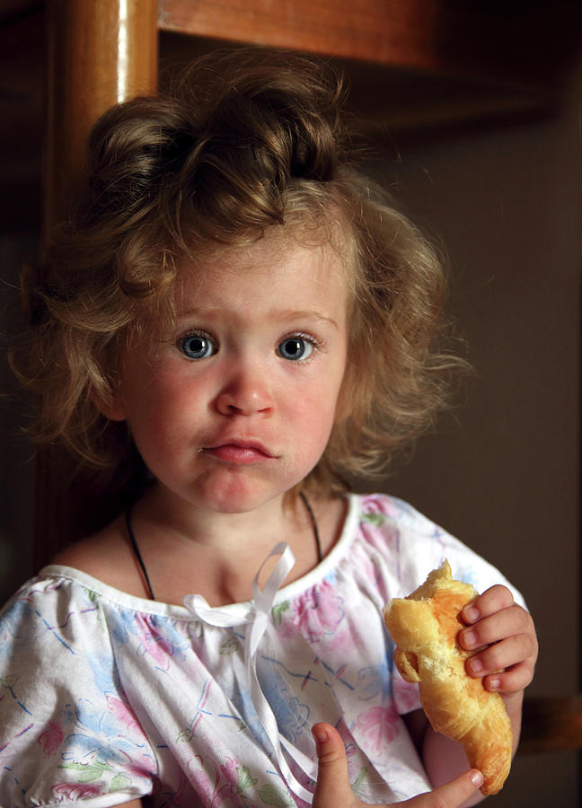 Little Girl Eating Croissant #1 Photograph by Mikhail Kokhanchikov