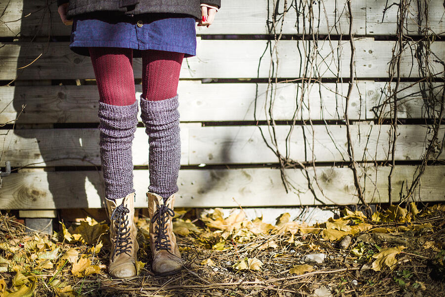 Lower body of a girl who has style that wears boots, red tights and knee socks #1 Photograph by Linda Raymond