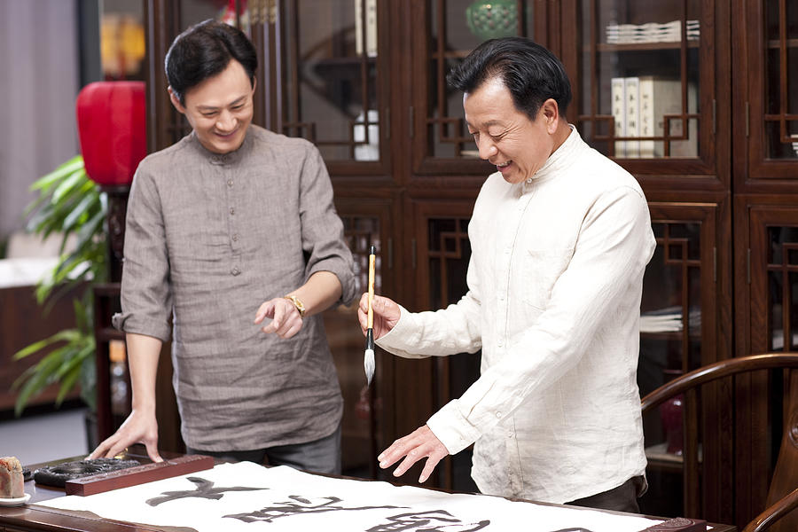 Male friends practicing calligraphy in the study #1 Photograph by BJI / Blue Jean Images