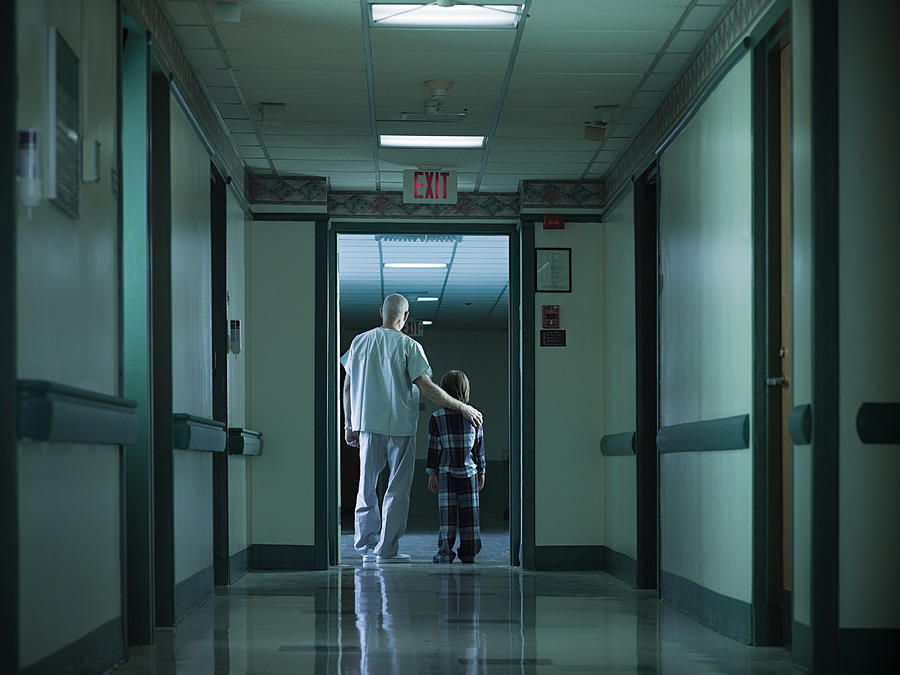 Male nurse and young boy in hospital corridor #1 Photograph by Image Source
