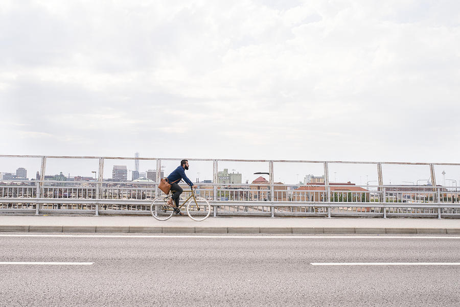 Man cycling on street #1 Photograph by Johner Images