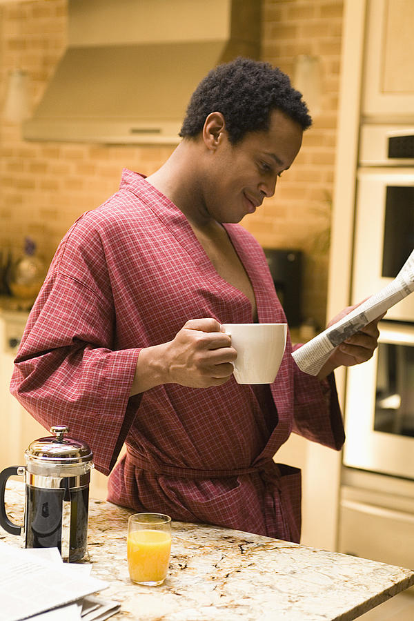 Man with coffee and newspaper #1 Photograph by Jupiterimages