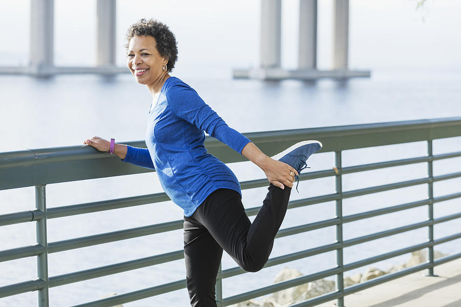 Mature African-American woman exercising on waterfront #1 Photograph by Kali9