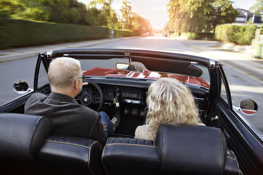 Mature couple driving convertible car in sunset #1 Photograph by Klaus Vedfelt