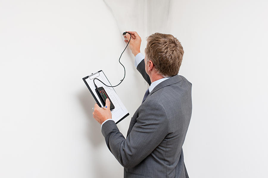Mature man examining damp patch on wall #1 Photograph by Image Source