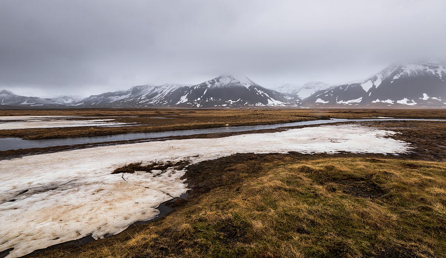 Meadow with snow and frozen lake and snowcapped mountains. Iceland #1 Photograph by Michalakis Ppalis