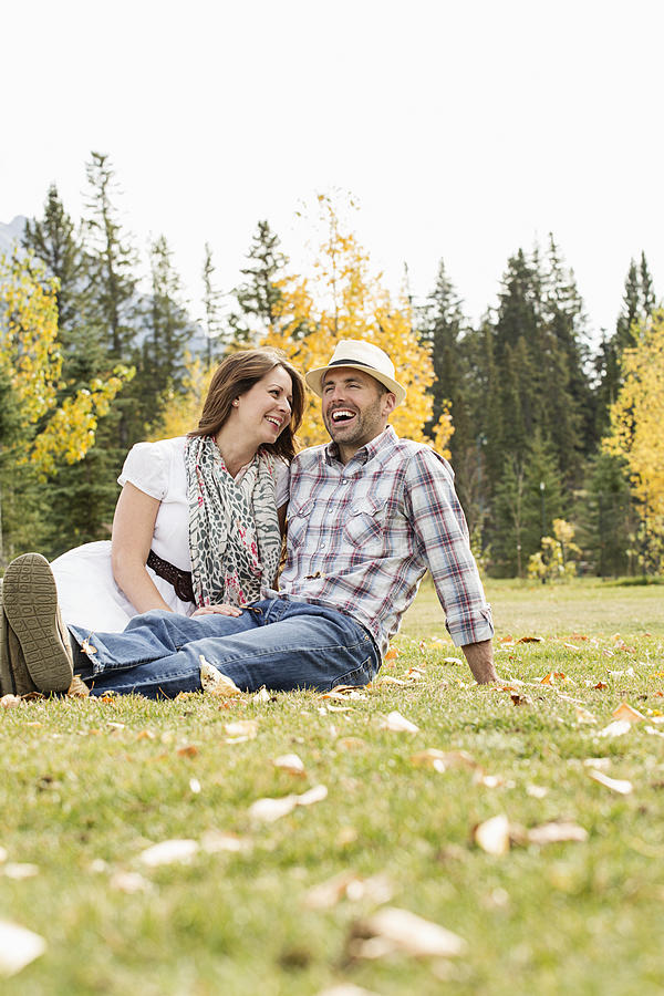 Mid-adult couple relaxing on grass #1 Photograph by Tammy Hanratty
