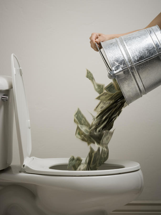 Mid adult woman emptying a bucket of money into a toilet bowl #1 Photograph by Rubberball
