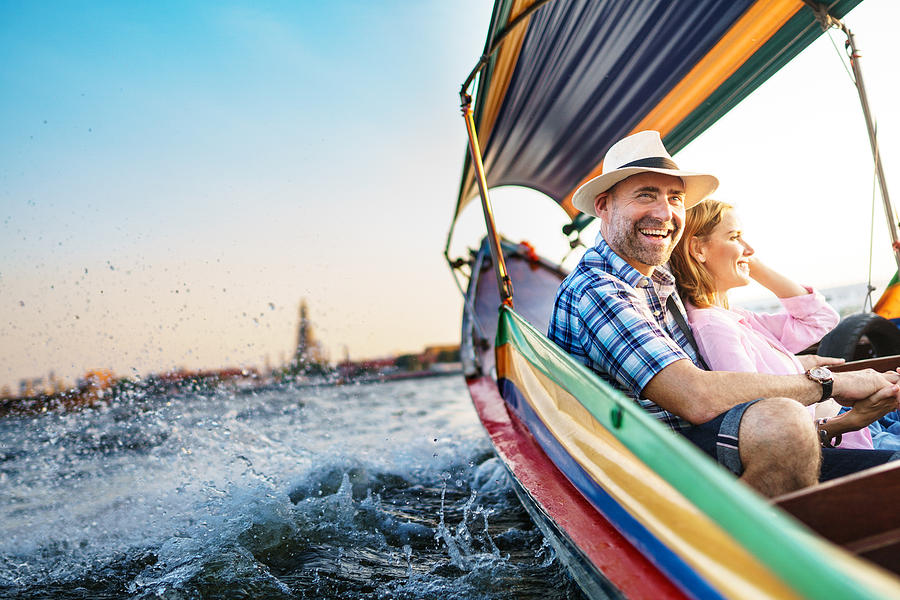 Middle-aged man and his companion handsome blond lady on a boat ride in Bangkok Photograph by Itsskin Middle-aged man and his companion handsome blond lady on a boat ride in Bangkok Photograph by Itsskin