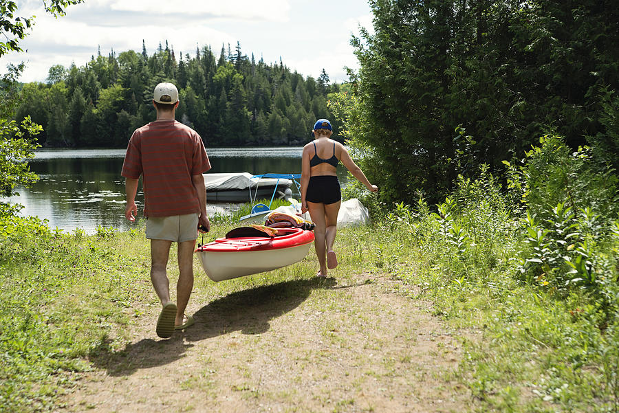 Millennial couple going kayaking on country lake. #1 Photograph by Martinedoucet