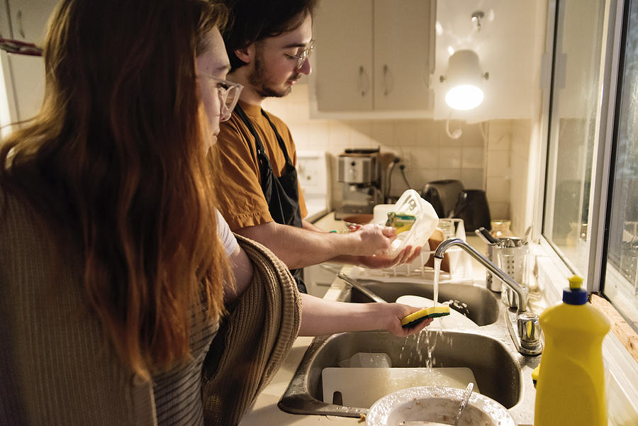 Millennial couple of students shared living doing chores. #1 Photograph by Martinedoucet
