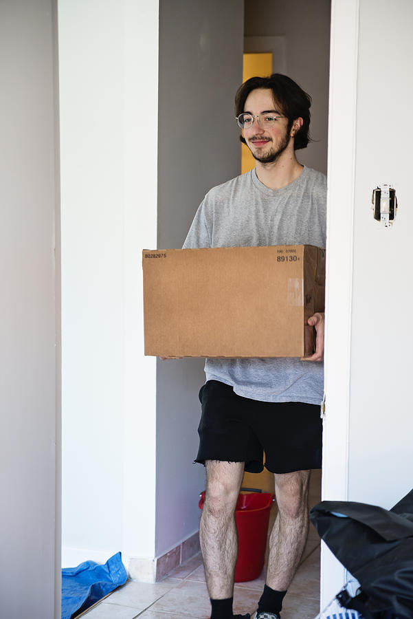 Millennial young man moving in new apartment. #1 Photograph by Martinedoucet