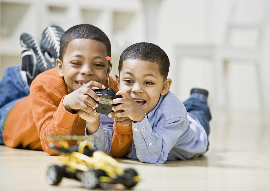 Mixed Race brothers playing with remote control car #1 Photograph by Andersen Ross Photography Inc