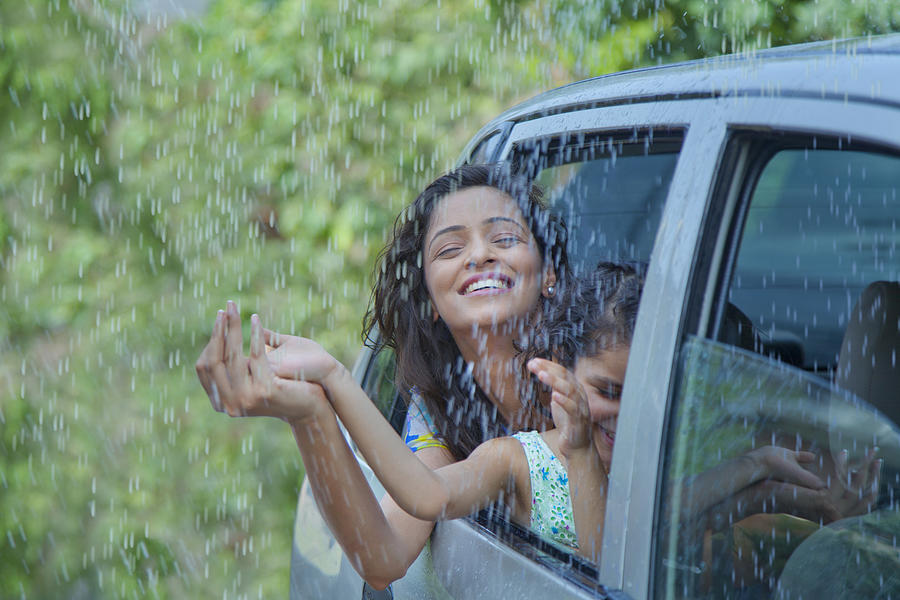 Mother and daughter enjoying the rain #1 Photograph by IndiaPix/IndiaPicture