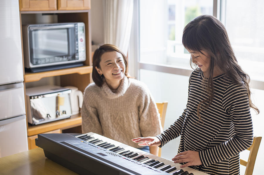 Mother and daughter playing  on electronic piano #1 Photograph by Yagi-Studio