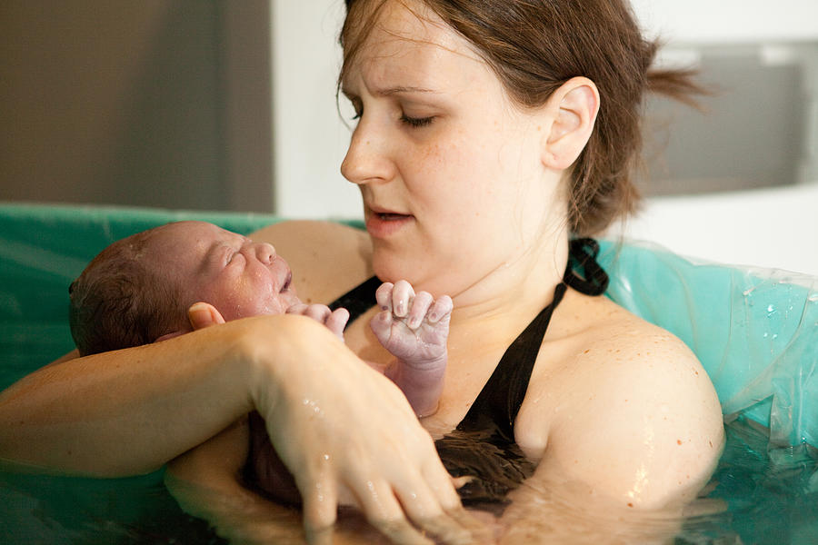 Mother Holding Newborn in Birthing Tub After Home Water Birth #1 Photograph by Ideabug