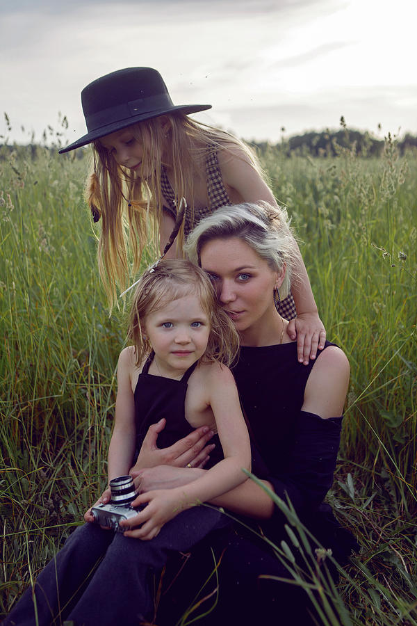 Mother In An Evening Dress And A Retro Camera With Two Daughters