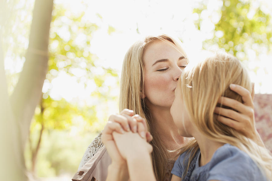 Mother kissing daughter outdoors #1 Photograph by Sam Edwards