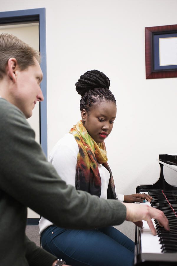 Music teacher and student practicing at piano #1 Photograph by Hill Street Studios