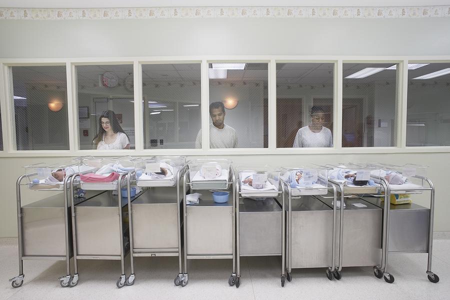 New parents watching babies in hospital nursery #1 Photograph by ER Productions Limited