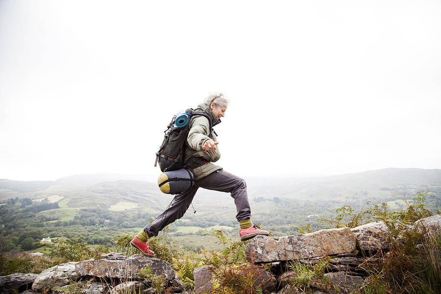 Older woman trekking in the mountains of ireland #1 Photograph by Jag Images