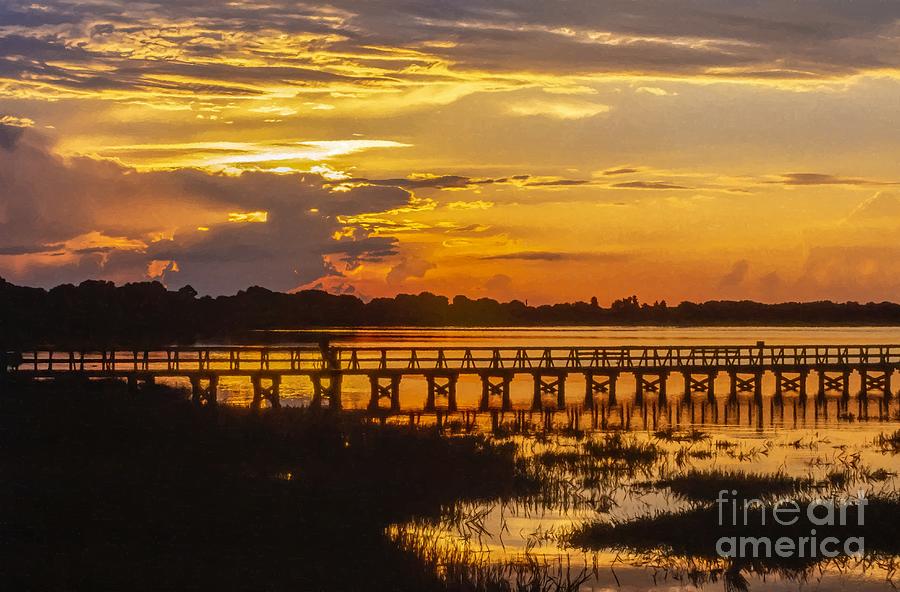 Orange sunset and a lone fisherman over Lake Mineola at Clermont Florida USA #1 Photograph by William Kuta