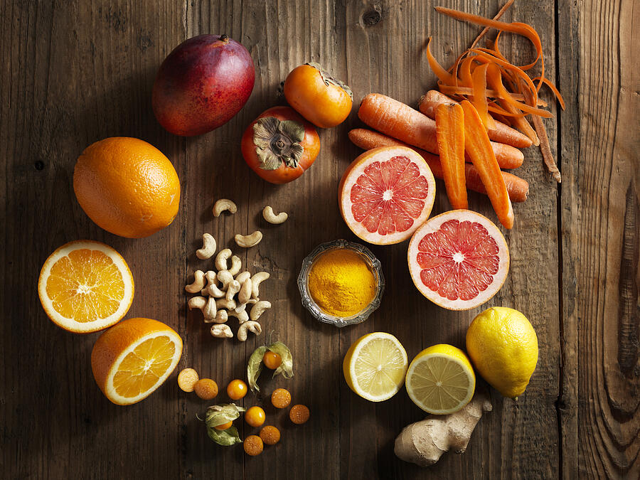 Overhead view of orange fruit and vegetables on wood grain pattern background #1 Photograph by WayUp Productions