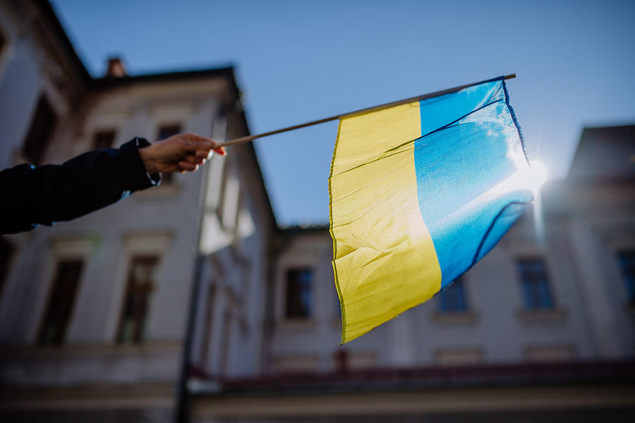 People holding Ukrainian flag and protesting against Russian invasion in Ukraine in streets. #1 Photograph by Halfpoint Images