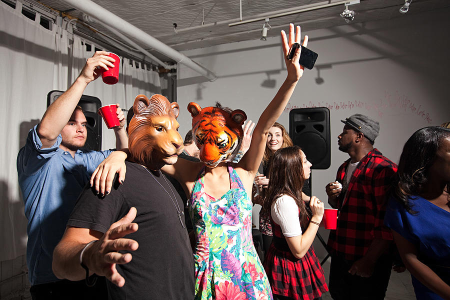 People wearing lion and tiger masks dancing at party #1 Photograph by Image Source