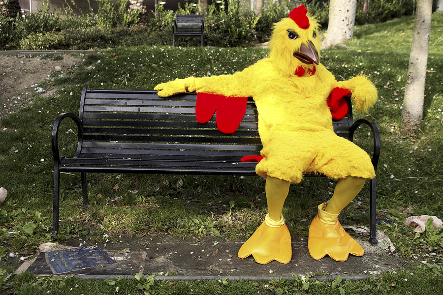 Person in chicken costume sitting on bench #1 Photograph by Eric Chuang
