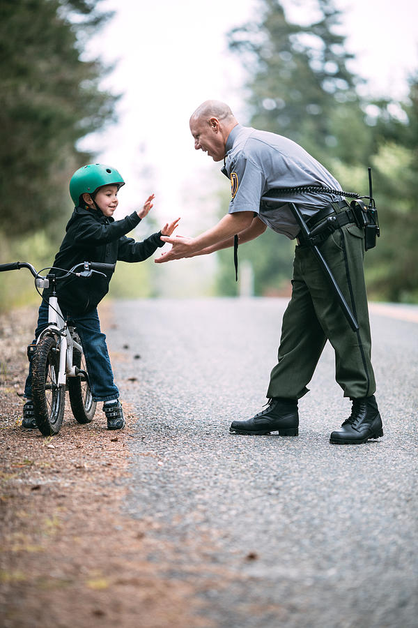 Police Officer Talking to Child on Bike #1 Photograph by RyanJLane