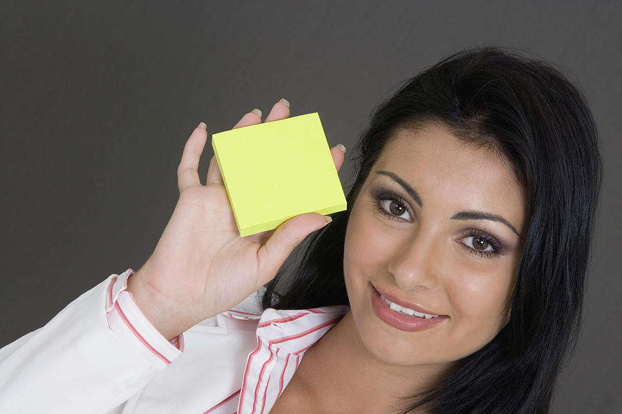 Portrait of a businesswoman holding a blank adhesive note and smiling #1 Photograph by Glowimages