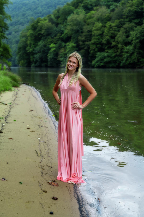 Pretty woman standing on shore in pink dress #1 Photograph by Dan Friend