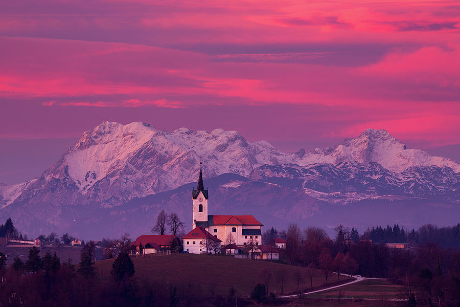Prezganje church with snowy Kamnik Alps in the background. #1 Photograph by Ian Middleton
