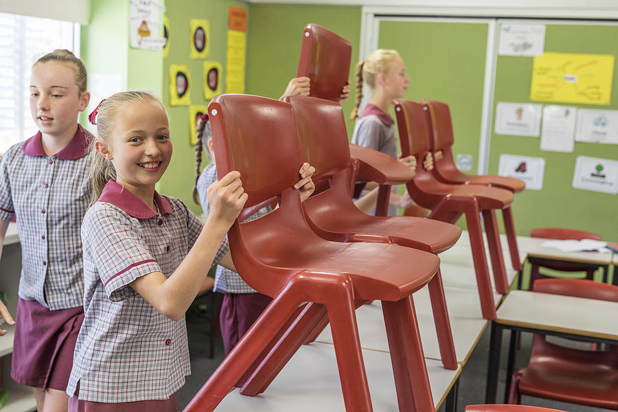 Primary School Students Putting Up Chairs at the End of Class #1 Photograph by Davidf