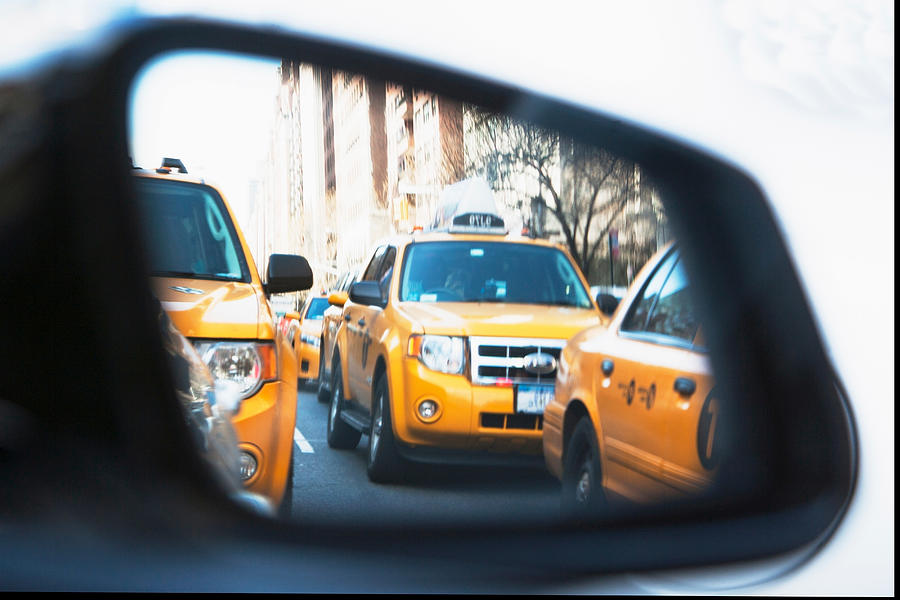 Queue of yellow cabs viewed through wing mirror, New York City, USA #1 Photograph by Ditto