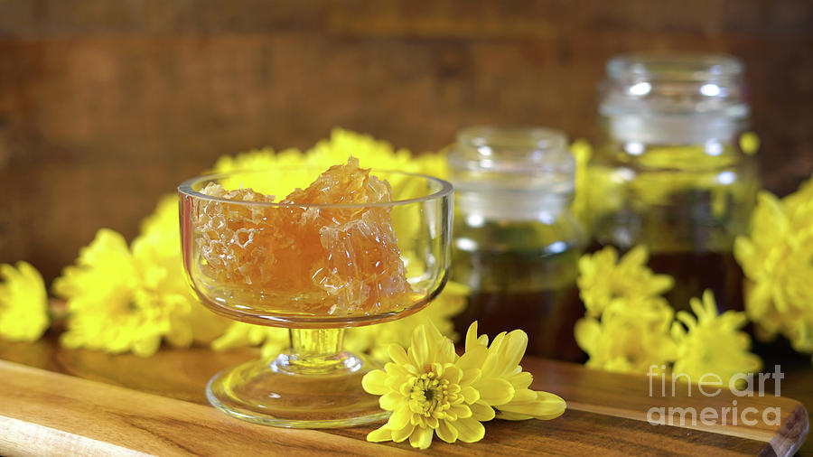 Raw honeycomb with liquid honey in glass jar with lavendar. #1 Photograph by Milleflore Images