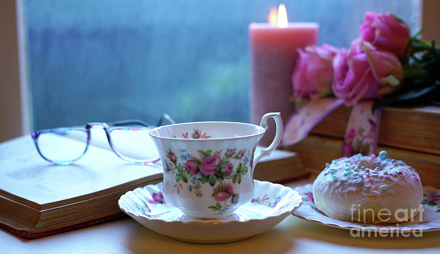 Relaxing by the window on a cold rainy day with books and cup of tea. #1 Photograph by Milleflore Images