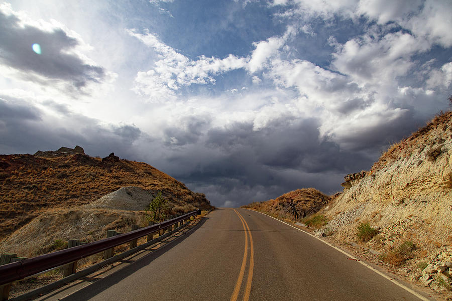 Road with clouds at Theodore Roosevelt National Park in North Dakota #1 Photograph by Eldon McGraw