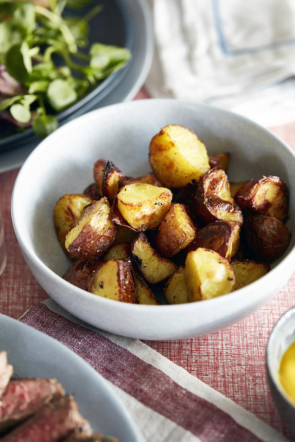 Roast potatoes in bowl, close-up #1 Photograph by Debby Lewis-Harrison