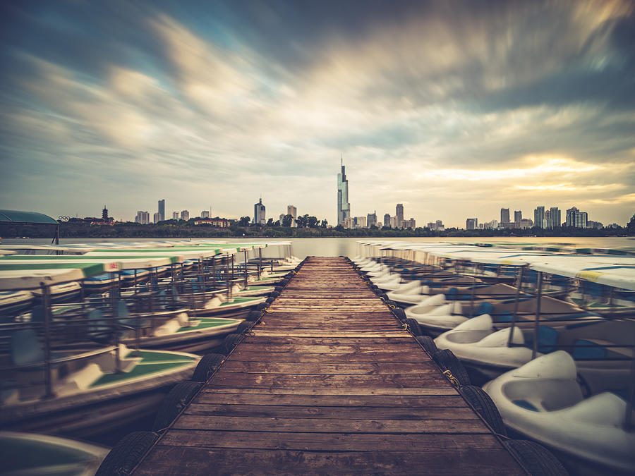 row of boats moored at xuanwu lakeside with the Zifeng Tower on background #1 Photograph by Aaaaimages