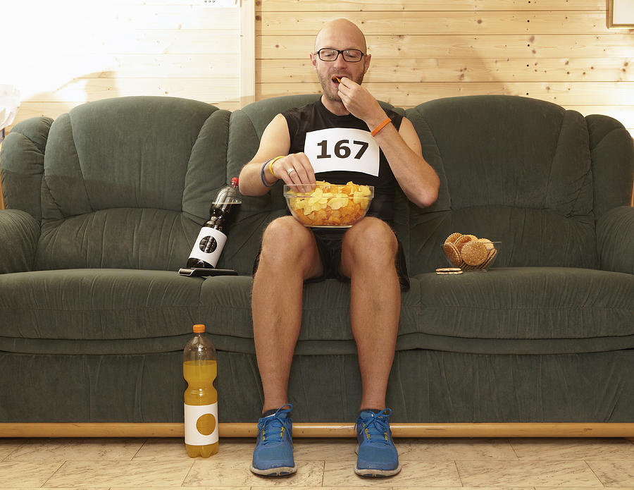 Runner eating chips on sofa #1 Photograph by Martin Leigh